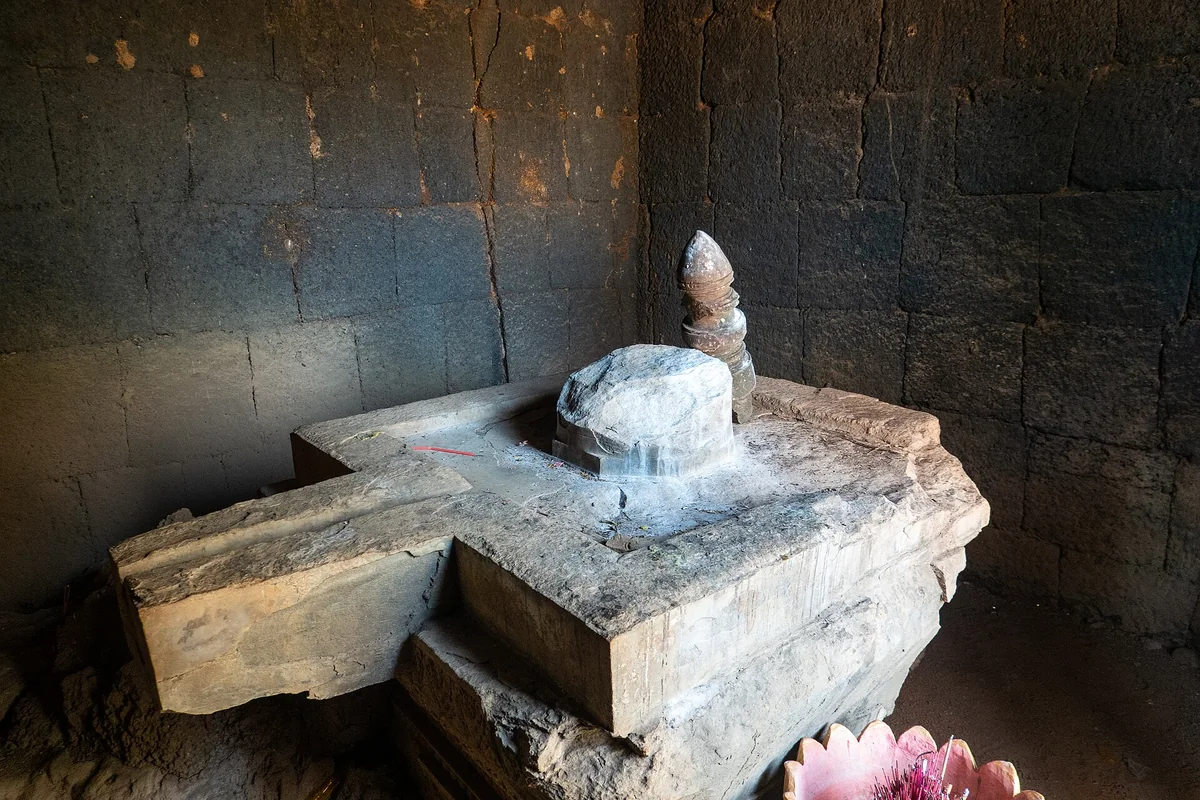 A linga on its base inside the dark stone sanctuary of Prasat Neang Khmau at Koh Ker, seen on Angkor Wat tours from Siem Reap