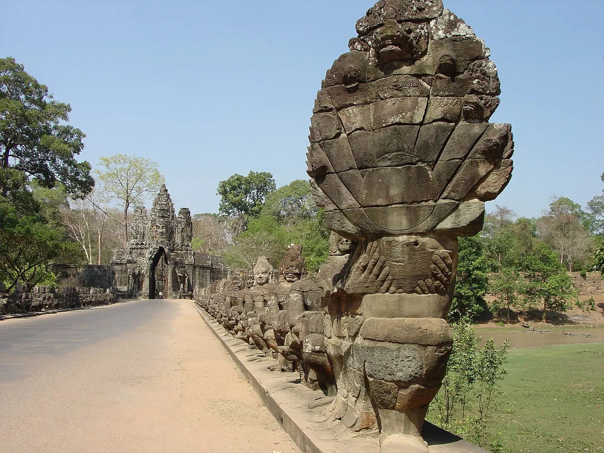 The causeway to Angkor Thom's south gate lined with a naga balustrade held by rows of stone figures, seen on Angkor Wat tours from Siem Reap