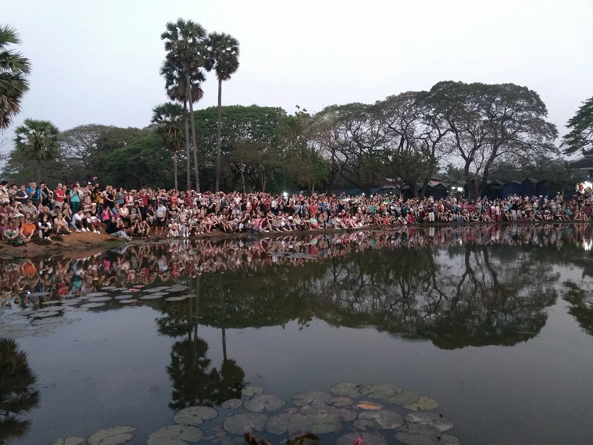 A line of visitors waiting at the reflecting pond for sunrise at Angkor Wat, seen on Angkor Wat tours from Siem Reap